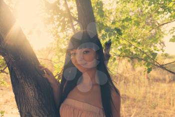 Brunette near tree backlit colorized image