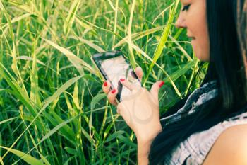 Women using tablet pc outdoors against grass