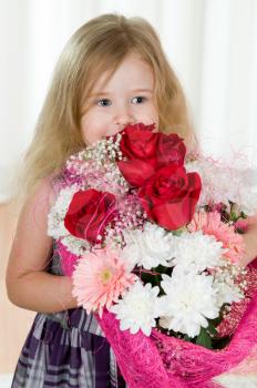 Royalty Free Photo of a Little Girl Holding a Bouquet of Flowers