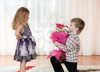 Royalty Free Photo of a Little Boy Giving a Girl Flowers