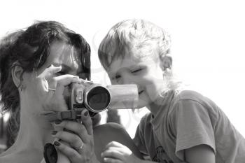 Royalty Free Photo of a Mother and Son Watching a Video Camera