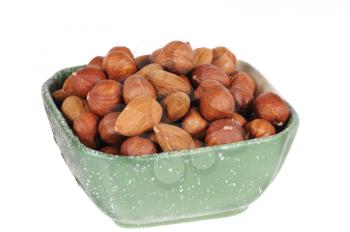 hazelnuts and almond in a cup isolated on white background