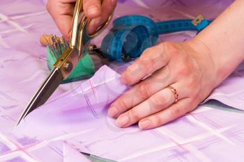 Royalty Free Photo of a Dressmaker Cutting Fabric