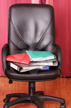 Royalty Free Photo of a Pile of Folders on a Chair