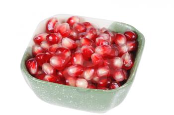 Pomegranate grains in a plate isolated on white background