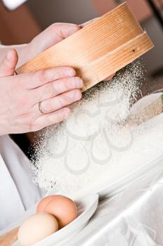 Royalty Free Photo of a Person Sifting Flour Through a Sieve
