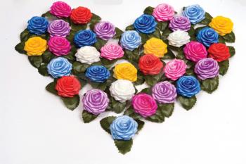 many-coloured plastics roses on a white background in shape heart