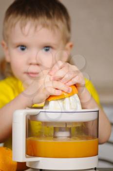 Royalty Free Photo of a Child Using a Juicer