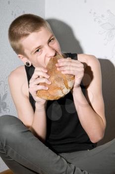 hungry teenager sitting in the corner and eat bread