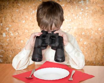 child looks at a plate throught a binoculars