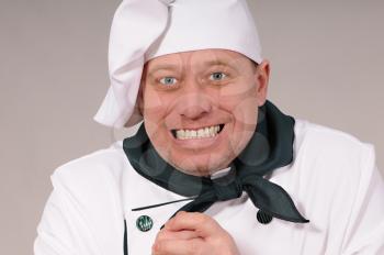 funny portrait of a cook on a gray background