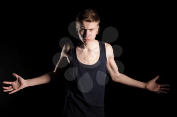 teenager showing muscles on the black background