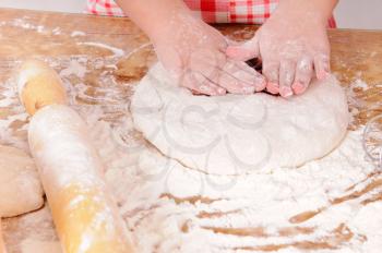 a little girl is cooking the dough for making biscuits