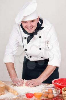 cook kneads the dough for cooking