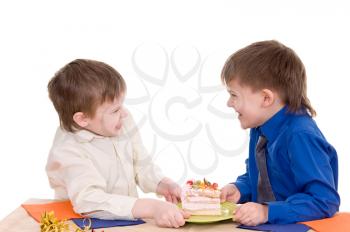 Two boys share a piece of cake on white background