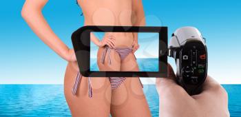 Royalty Free Photo of a Woman in a Bikini Being Filmed by a Camcorder
