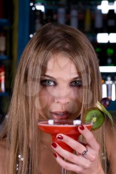 Royalty Free Photo of a Woman Drinking a Cocktail in a Bar