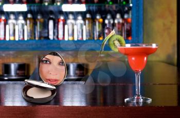 Royalty Free Photo of a Cocktail on a Bar and Woman's Face Reflected in a Mirror