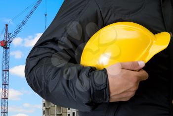 Royalty Free Photo of a Builder Holding a Yellow Helmet