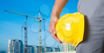 Royalty Free Photo of a Builder Holding a Yellow Helmet