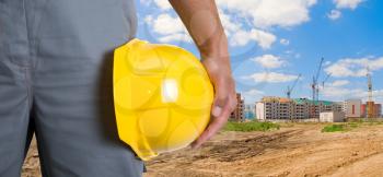 Royalty Free Photo of a Builder Holding a Yellow Hardhat