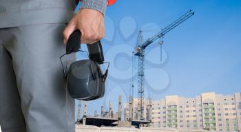 Royalty Free Photo of a Builder Holding Protective Headphones