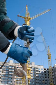 Royalty Free Photo of a Man's Hands Closeup With a Crane Hook at a Building