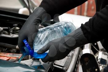 Royalty Free Photo of a Mechanic Filling Washing Liquid in a Car