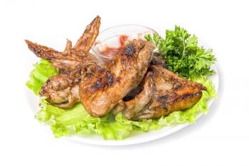 Tasty grilled chicken wings with vegetables and sauce
