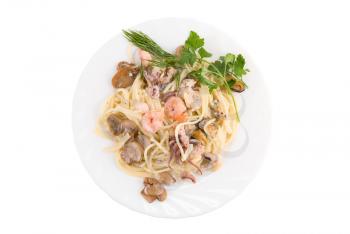 Pasta with seafood and mushrooms on white plate