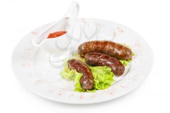 grilled venison sausage on a white with lettuce and sauce