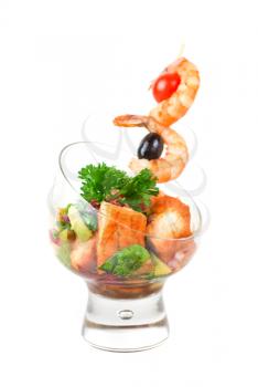 Fried kebab of shrimps with vegetables, greens and salmon fish