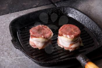 Royalty Free Photo of Beef Steak Grilling in a Cast-Iron Pan