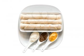 Flat cake and assortment of spices in the spoons on white  background