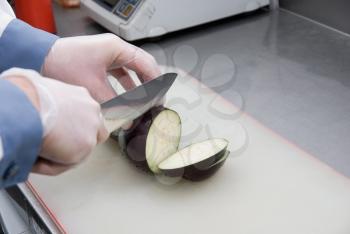 Royalty Free Photo of a Cook Cutting a Zucchini 