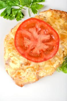 Royalty Free Photo of Roasted Pork Steak Baked With Cheese and Tomato