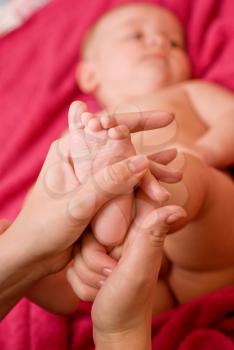 Royalty Free Photo of a Mother Massaging Her Baby's Feet
