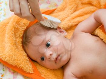 Royalty Free Photo of a Mother Combing Her Baby's Hair