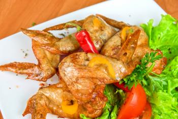 Royalty Free Photo of Roasted Chicken Wings Garnished With Fresh Peppers