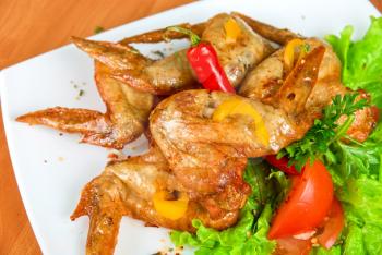 Royalty Free Photo of Roasted Chicken Wings Garnished With Fresh Peppers