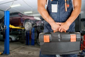 Royalty Free Photo of a Mechanic Holding a Toolkit 