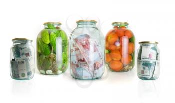 Royalty Free Photo of Glass Jars With Cucumbers, Tomatoes and Money in Them