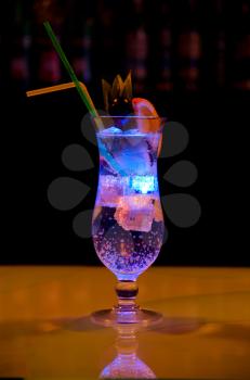 Light cocktail with orange and pineapple with soda at dark background