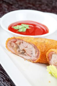 Closeup of rolls from pork meat, champignon mushroom, cheese and sauce