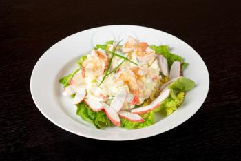 Salad of shrimps, crab meat, cucumbers, apples, potatoes, lettuce, maize, eggs and mayonnaise