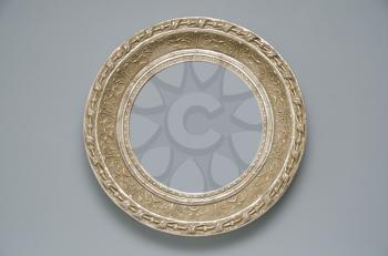 Picture gold frame with a decorative pattern on a gray wall