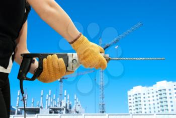 Construction worker building with drill on a building background