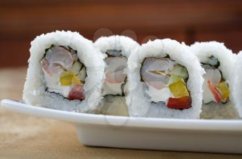 sushi roll of shrimp, cucumber, pepper and sauce, closeup