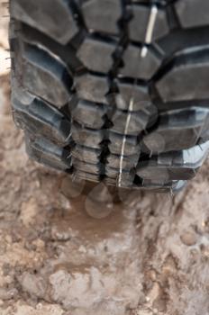Close up of a car tire on a dirty road.