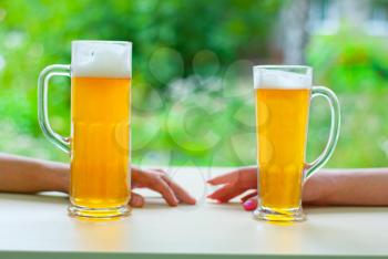 two human hands, man and woman with beer in glass.